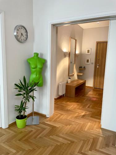 a hallway with a clock on the wall and a plant at Lycabettus Luxury Cave greendom in Athens