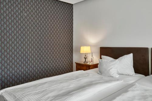 a bedroom with a white bed with a patterned wall at Hotel Kraft in Munich