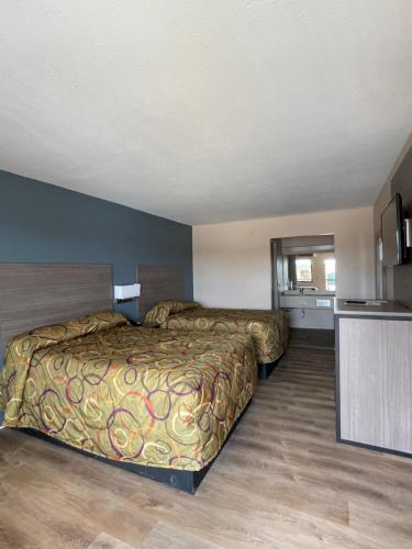 Habitación de hotel con 2 camas y cocina en Garden Inn & Suites, en Hogansville
