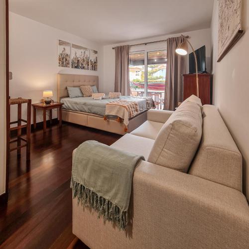 a living room with a couch and a bed at Atrium Studio Cascais in Cascais