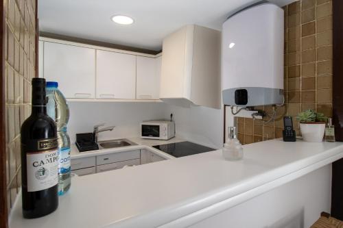 a bottle of wine sitting on a counter in a kitchen at Atrium Studio Cascais in Cascais