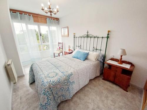 1 dormitorio con 1 cama con edredón azul y blanco en Apartamento con vistas al mar en la playa de Vilagarcia - O Feitizo, en Vilagarcía de Arousa