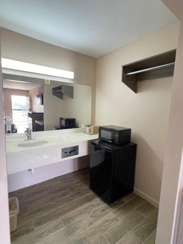 a bathroom with a sink and a large mirror at Garden Inn & Suites in Hogansville