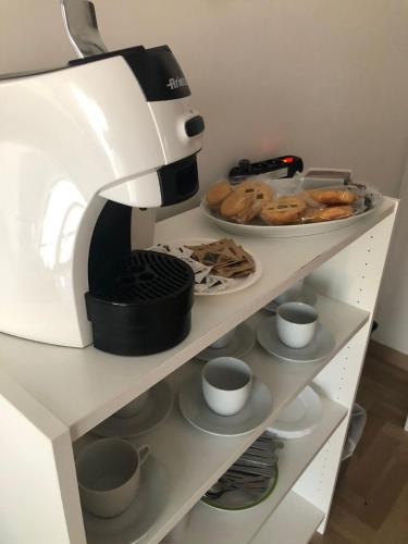 a coffee maker sitting on a shelf with pastries at B&B Stella marina in Porto Recanati
