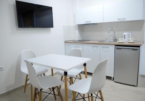 a kitchen with a white table and white chairs at Villa Sandra Lagadin in Ohrid