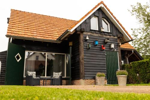 a small house with a green door and windows at Veldschuur Nijverdal in Nijverdal