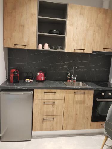 a kitchen with wooden cabinets and a black counter top at K35 Apartments in Preveza
