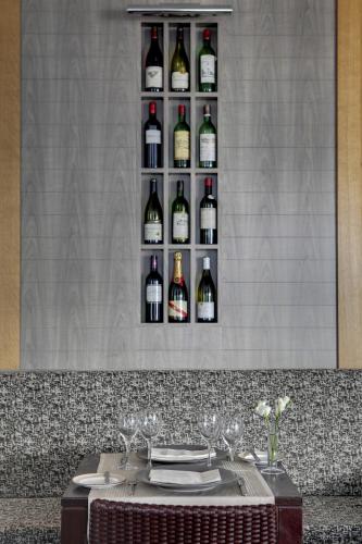 a table with glasses and wine bottles on a wall at Best Western Plus Paris Saclay in Saclay