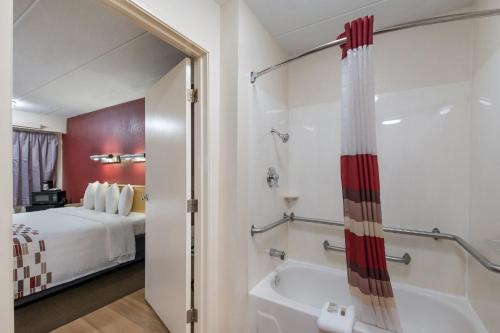 a hotel room with a bathroom with a tub and a bed at Red Roof Inn Philadelphia - Trevose in Trevose