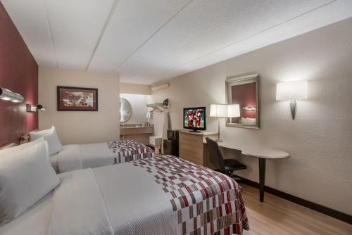 a hotel room with a bed and a desk at Red Roof Inn Philadelphia - Trevose in Trevose