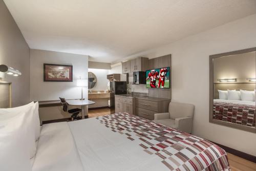 a hotel room with a large bed and a desk at Red Roof Inn Philadelphia - Trevose in Trevose