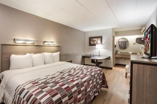 a hotel room with a bed and a television at Red Roof Inn Philadelphia - Trevose in Trevose