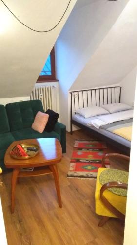 un soggiorno con divano, letto e tavolo di Apartmán Zlaté časy na Trojici a Banská Štiavnica