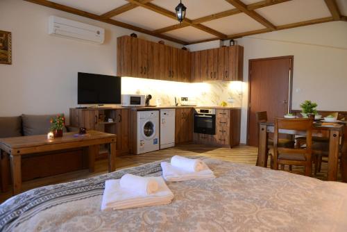 a living room with a bed and a kitchen with a table at Family Hotel Gotse Delchev in Gotse Delchev