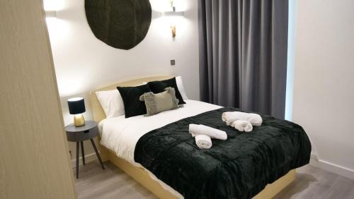 Un dormitorio con una cama con toallas blancas. en MK shortstay Deluxe- Capital Drive en Milton Keynes