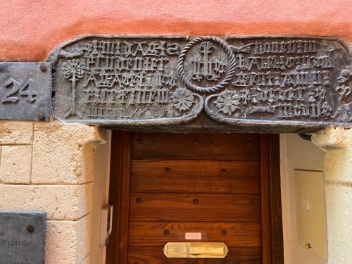 un panneau en pierre au-dessus d'une porte en bois sur un bâtiment dans l'établissement Suite 