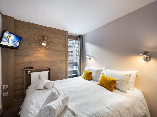 - une chambre avec un grand lit blanc et des oreillers jaunes dans l'établissement Appartement Val-d'Isère, 3 pièces, 6 personnes - FR-1-567-66, à Val dʼIsère