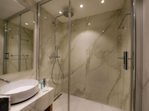 La salle de bains est pourvue d'une douche avec un lavabo et une porte de douche en verre. dans l'établissement Appartement Val-d'Isère, 3 pièces, 6 personnes - FR-1-567-66, à Val dʼIsère