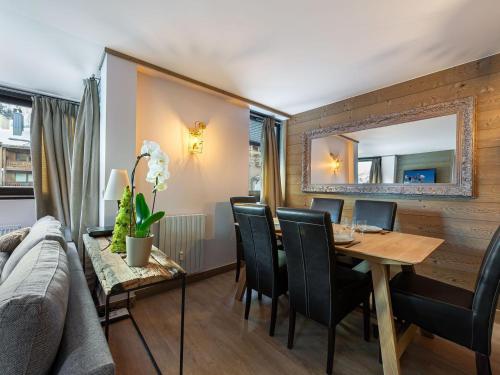 une salle à manger avec une table en bois et des chaises noires dans l'établissement Duplex moderne à 100m des pistes, WIFI, casier à skis - FR-1-567-66, à Val dʼIsère
