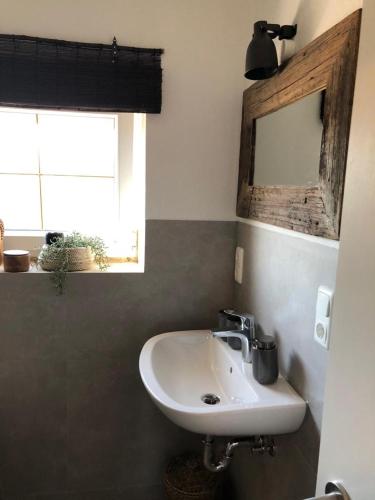 a bathroom with a sink and a mirror and a window at Ferien im Herzen Bayerns 2 in Töging am Inn