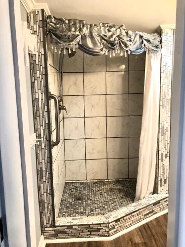 a bathroom with a shower with a tiled shower at Belmont Inn in Shelbyville