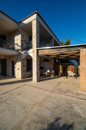 a large brick house with a porch and a patio at Gold Sun Villas in Nafplio