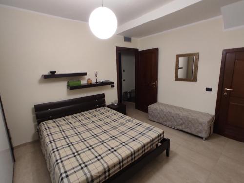 ein Schlafzimmer mit einem Bett, einem Spiegel und einer Lampe in der Unterkunft Casa Stella in Torre Grande
