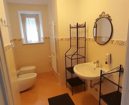 uma casa de banho com um lavatório, um WC e um espelho. em Villa Geltrude em Cusio