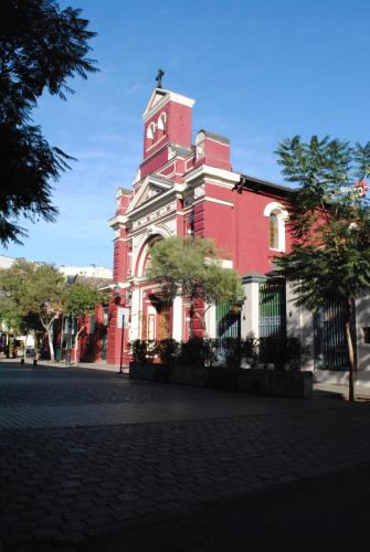 a red and white building with a clock tower at Barrio Lastarria, Excelentes Apartamentos - Sofia Camilla Propiedades in Santiago