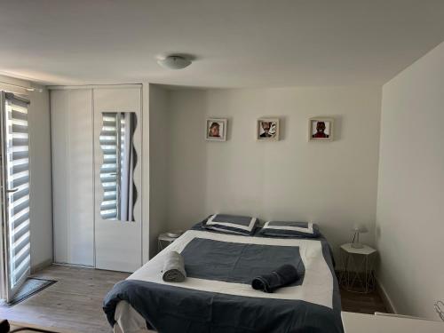 um quarto com uma cama num quarto branco em Studio calme et indépendant proche Tours em Fondettes