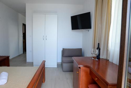 a living room with a table and a couch and a television at Villa Sandra Lagadin in Ohrid