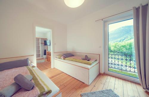 a bedroom with two beds and a large window at Schlosstaverne Lunz in Lunz am See