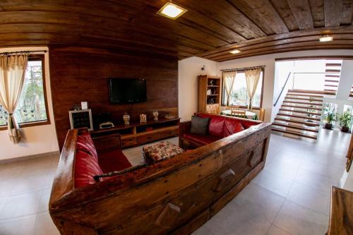 Una gran sala de estar con un sofá y un televisor. en Horizonte de Lavras, en Lavras Novas