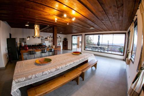 Un comedor con una mesa y un gran ventanal. en Horizonte de Lavras, en Lavras Novas