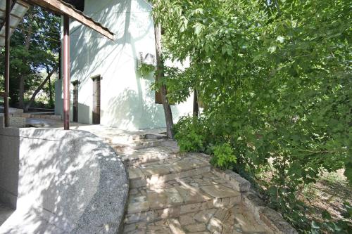 a stone walkway next to a building with a tree at Forest Hills in Yerevan