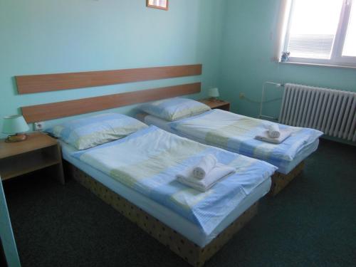 two beds in a room with towels on them at Penzion Premona in Nitra
