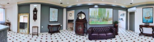 a room with a clock and a couch and a mirror at Penelope Apartment Hotel in Dassia