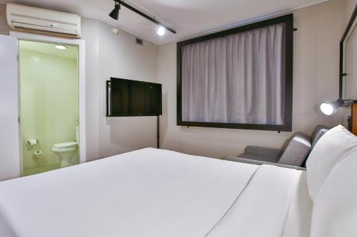 a bedroom with a large white bed and a television at ibis Copacabana Posto 2 in Rio de Janeiro