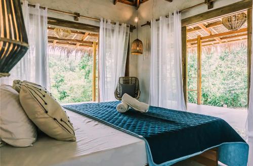 Una cama en una habitación con una maleta encima. en Eden, en El Nido