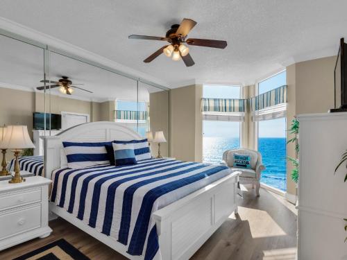 a bedroom with a bed with a blue and white striped blanket at Jade East Towers 0730 by Newman-Dailey in Destin
