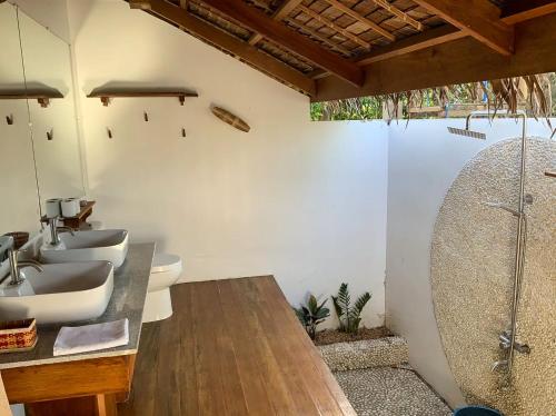 un baño con dos lavabos y una ducha en Eden, en El Nido