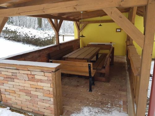 a pavilion with wooden benches and a brick wall at Jedlinka 37 in Klášterec nad Orlicí