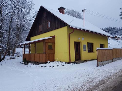a yellow house with a snow covered roof at Jedlinka 37 in Klášterec nad Orlicí