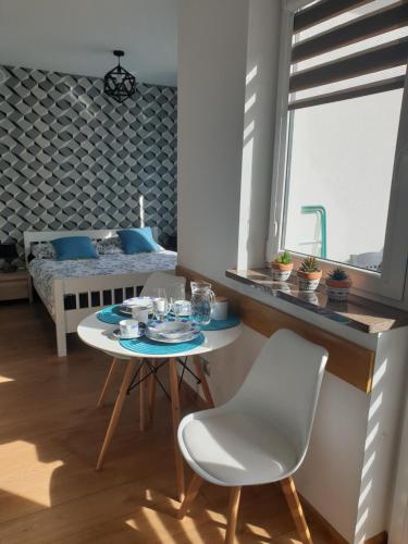 a room with a table and chairs and a bed at VILLA MILA Apartamenty in Karpacz