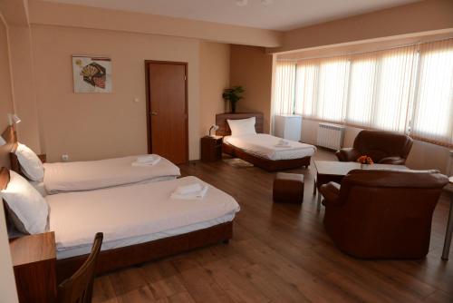 a hotel room with two beds and a living room at Family Hotel Gotse Delchev in Gotse Delchev