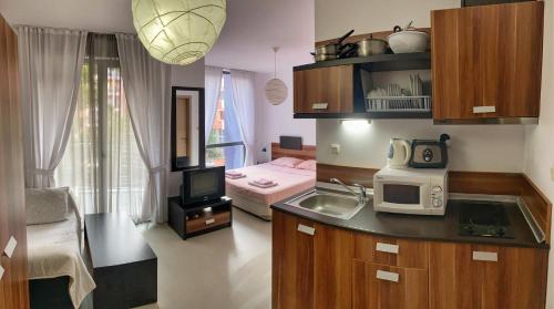 Il comprend une cuisine avec un évier et une chambre avec un lit. dans l'établissement Rainbow 3 Apartment-studio 223, à Sunny Beach