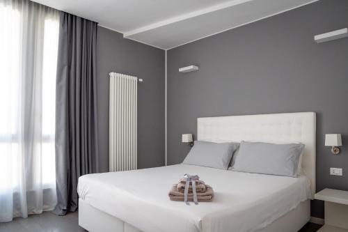 1 dormitorio con 1 cama blanca grande y toallas. en Midnight in Genova en Génova