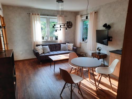 a living room with a couch and a table and chairs at Meerhuuske Käthe in Südbrookmerland