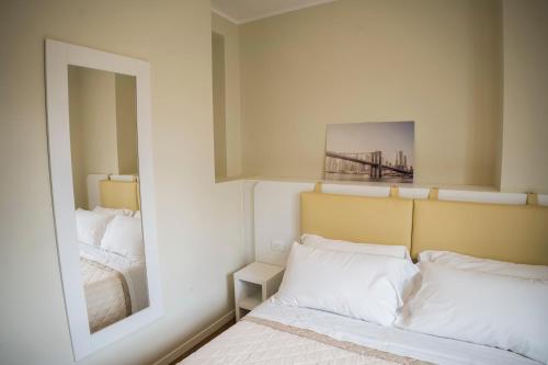a bedroom with a mirror and a bed with white pillows at Balconi Del Conero in Numana