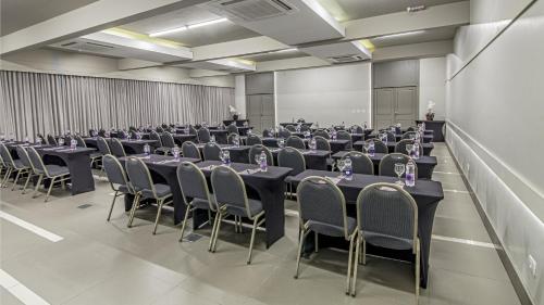 a large room with tables and chairs in it at Hotel Deville Express Cascavel in Cascavel